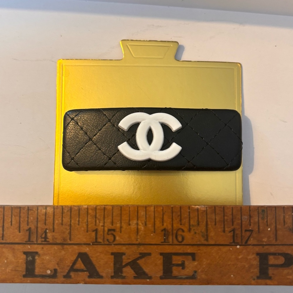 Black faux leather hair clip with white monogram